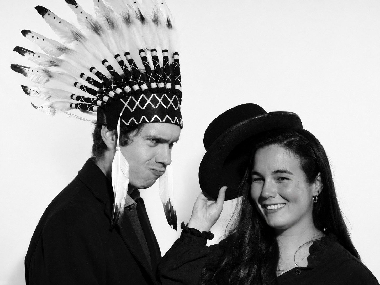 FOTOMATON BLACK & WHITE 4 Dos invitados posando con sombrero y accesorio de plumas en Black & White