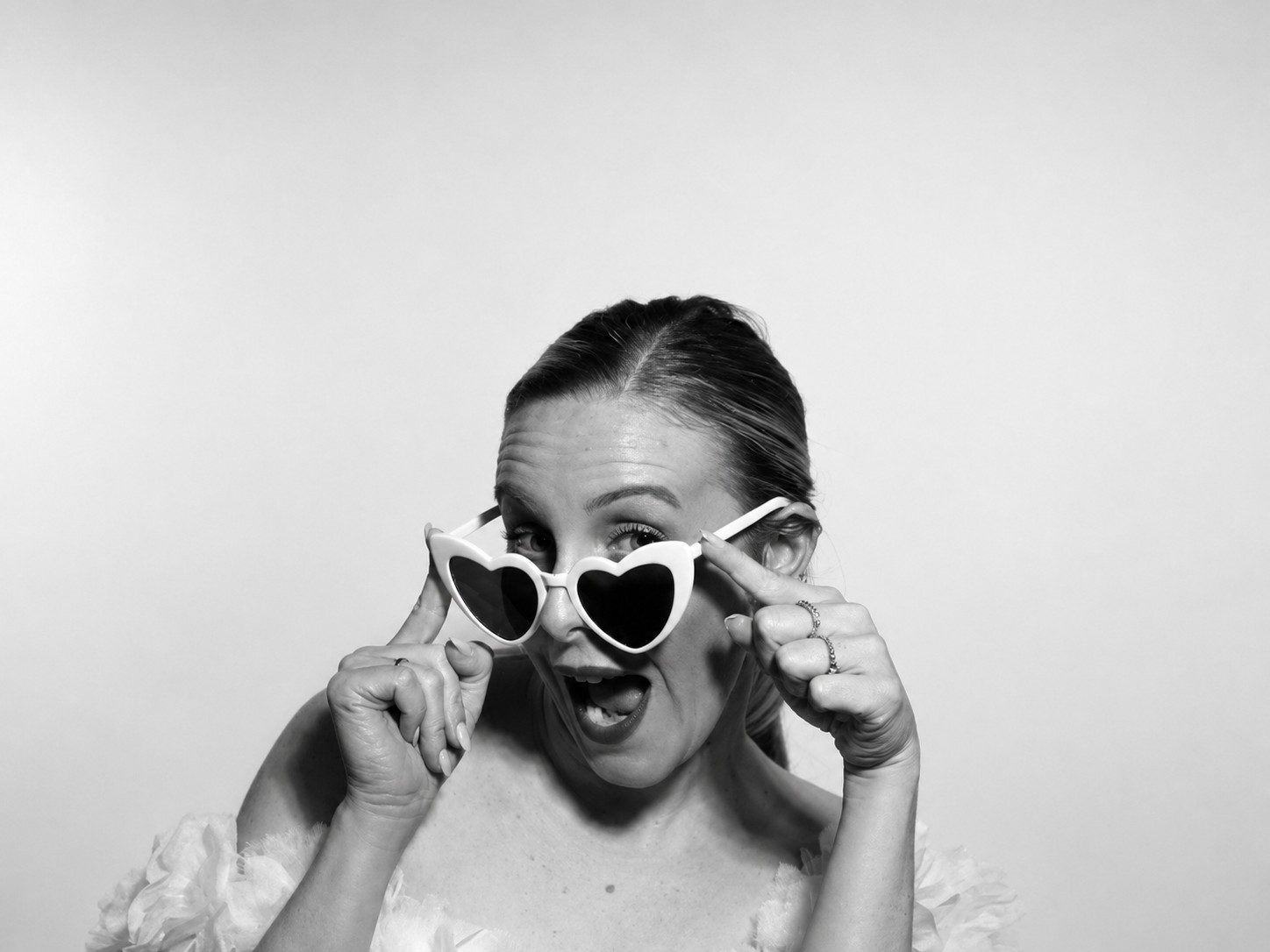 FOTOMATON BLACK & WHITE 5 Invitada con gafas de corazón en un retrato en blanco y negro